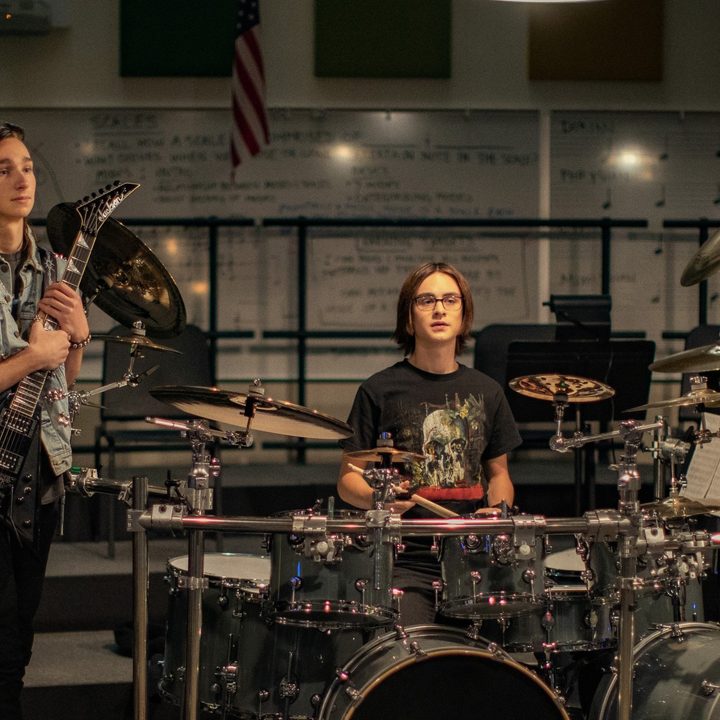 Adrian Greensmith and Jaeden Martell practice on guitar and drums in a scene from Metal Lords.