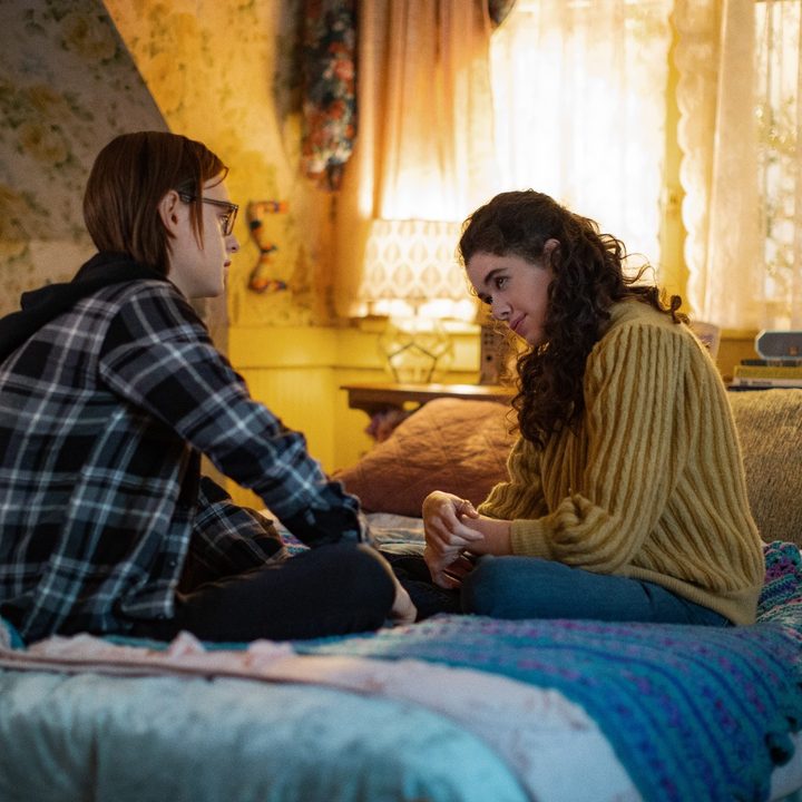 Jaeden Martell and Isis Hainsworth sit on a bed in a scene from Metal Lords.