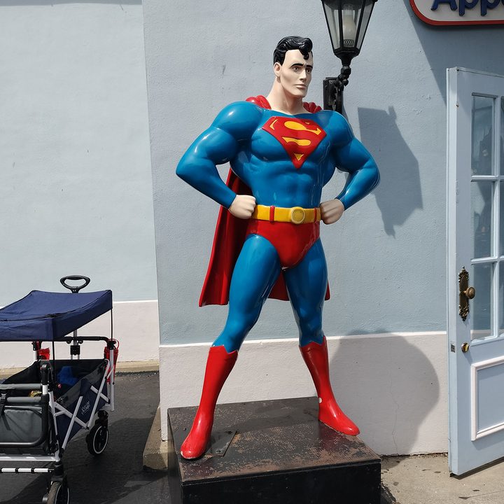 A Superman statue posed with hands on hips.