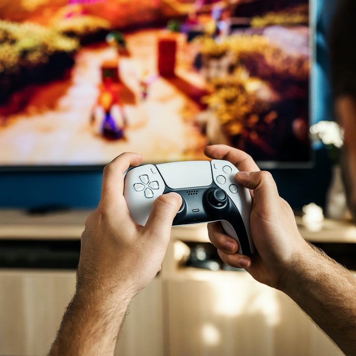 A person plays Crash Bandicoot using a PS5 DualSense controller.