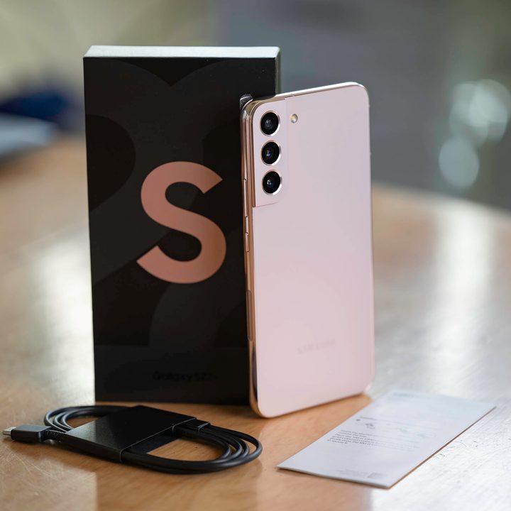 The Samsung Galaxy S22+ with box and accessories on a table.