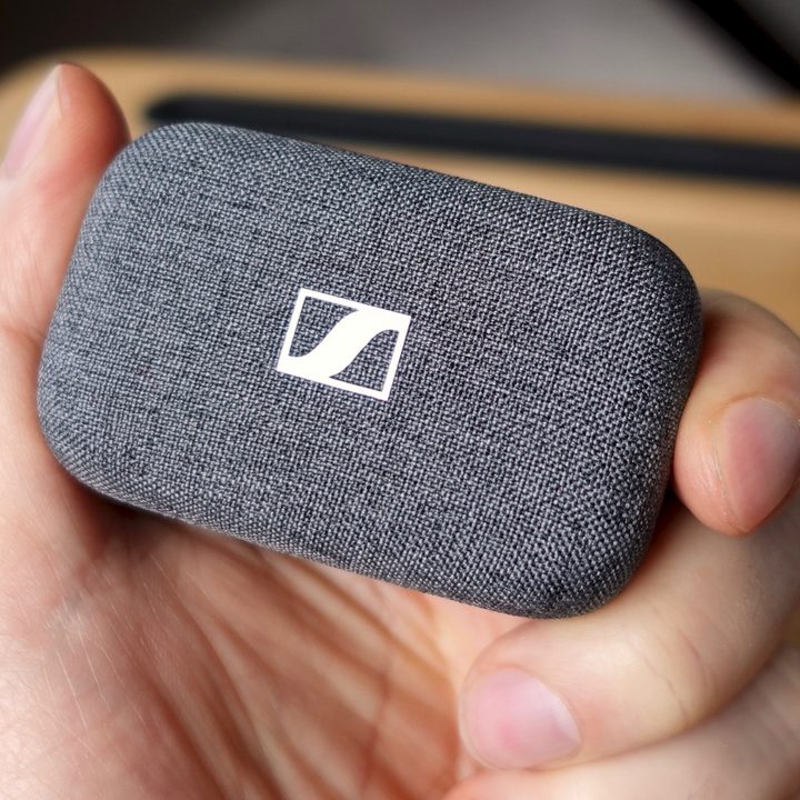 Hand holding Sennheiser Momentum True Wireless 3 charging case.