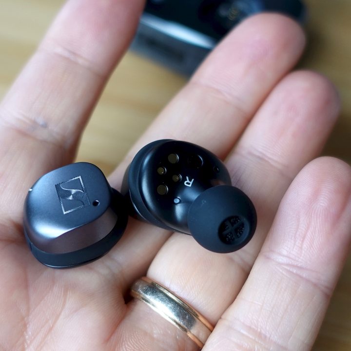Hand open, holding Sennheiser Momentum True Wireless 3.