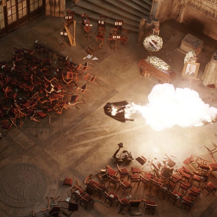 The Batman flies through the air after a bomb explodes in city hall.