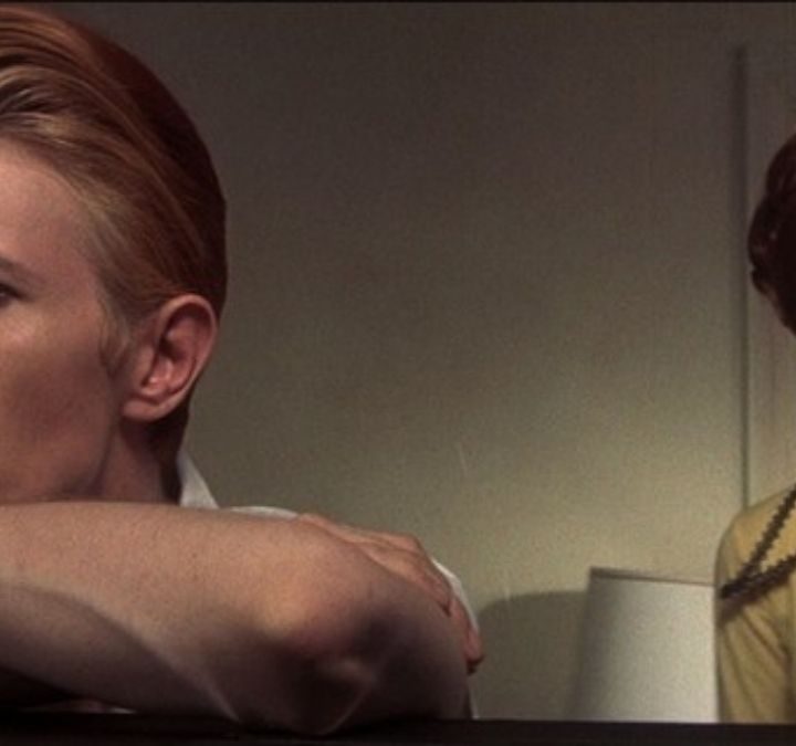 Thomas looking pensive whiloe Mary-Lou stands behind him in The Man Who Fell to Earth.