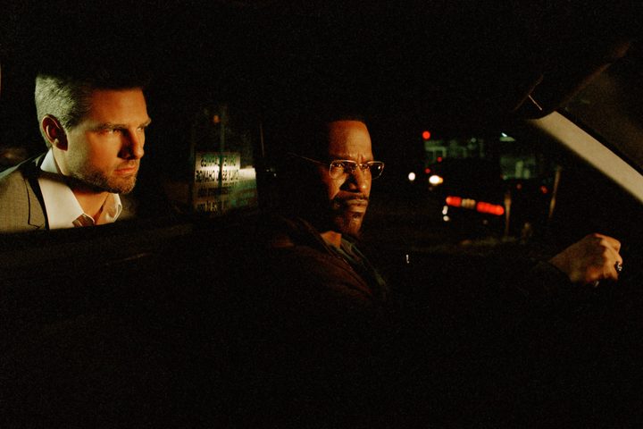 Tom Cruise sits behind Jamie Foxx in a taxicab in Michael Mann's Collateral.
