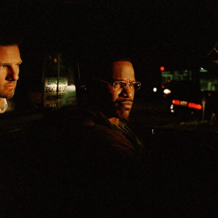 Tom Cruise sits behind Jamie Foxx in a taxicab in Michael Mann's Collateral.