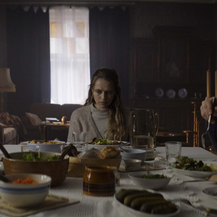 Elliot, Anthony, and Rachel all sitting around the table in a scene from The Twin.