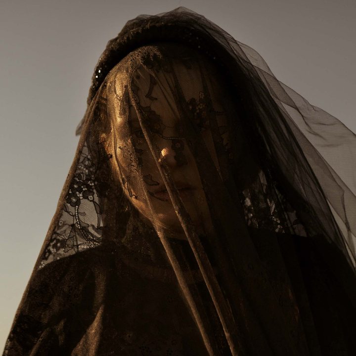 Rachel is covered in a black veil as she looks confused in a scene from The Twin.