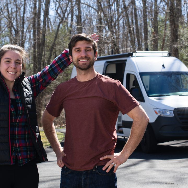 A couple posing in front of their converted Sprinter van