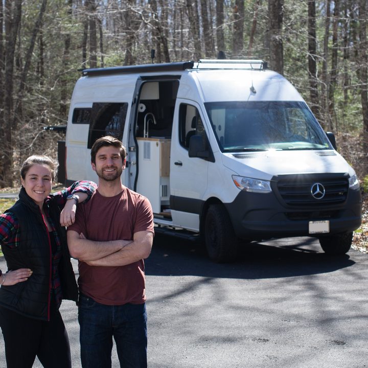 A couple standing in front of a converted sprinter van