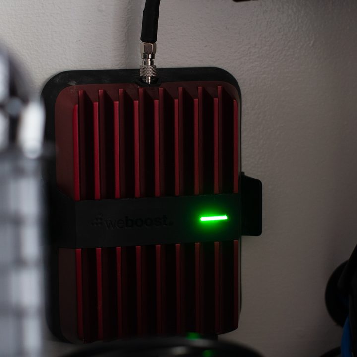 A closeup picture of a WeBoost receiver unit inside an RV cabinet