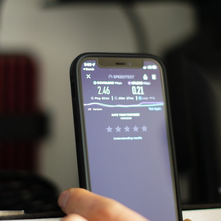 A closeup of a smartphone showing a speed test in front of an RV cabinet
