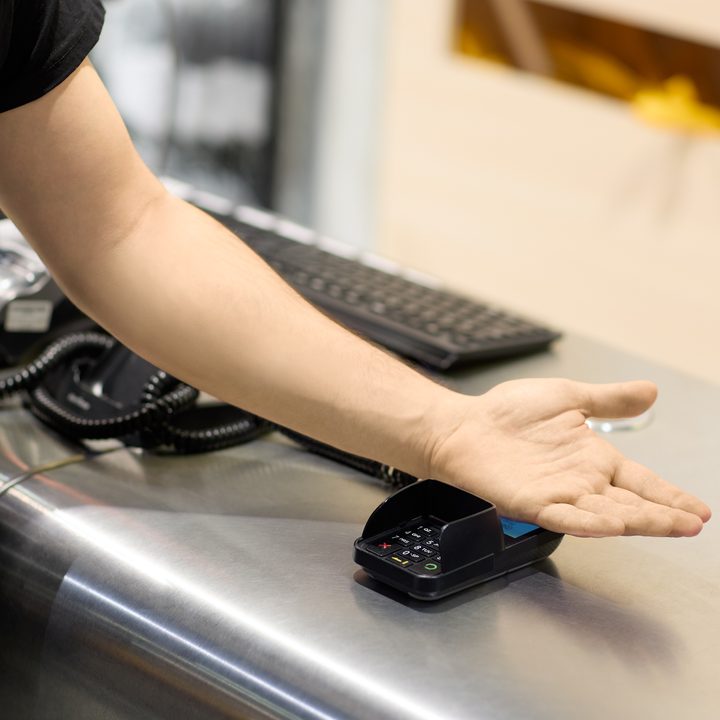 A person using Walletmor chip arm implant to make a payment.