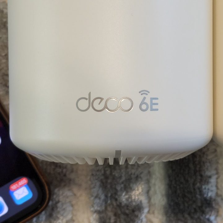 The front logo of the TP-Link Deco XE75.