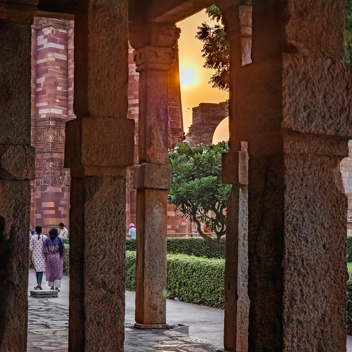 Edited image of the sun through pillars near the Indian monument Qutub Minar shot on the Samsung Galaxy S22 Ultra in RAW.