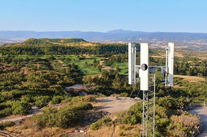 5G cellular tower over rural countryside.