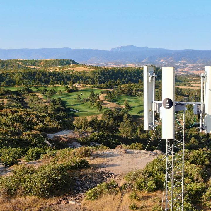 5G cellular tower over rural countryside.
