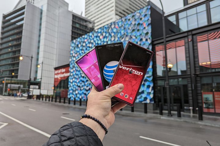 Hold holding three phones from three different carriers.
