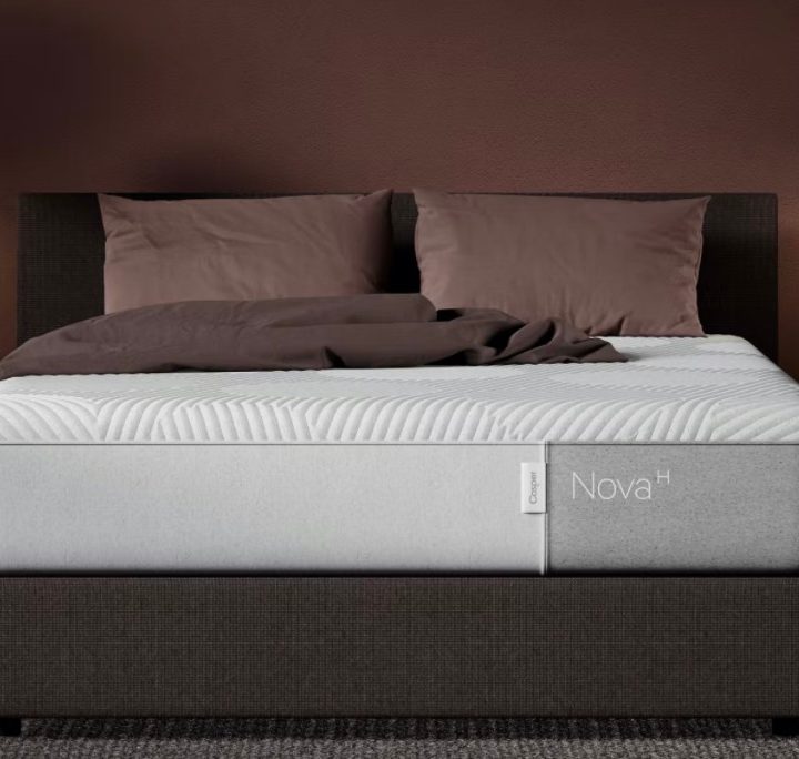 A Casper Nova Hybrid Mattress sits on a bed frame in a brown bedroom.