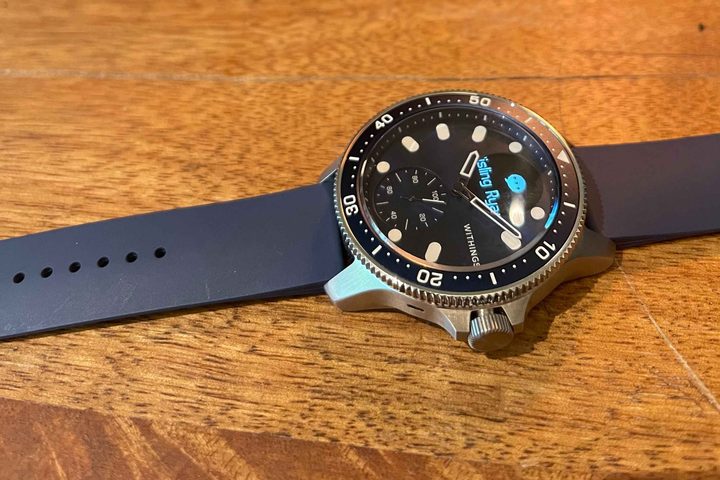 The Withings ScanWatch Horizon sits on a wooden surface.