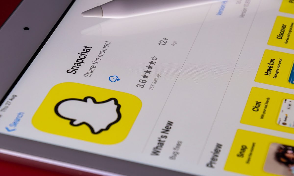 The Snapchat app store listing on a mobile device with a stylus resting on it.