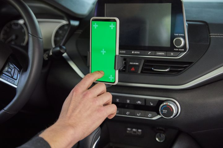 A driver using the Uber app in his car.