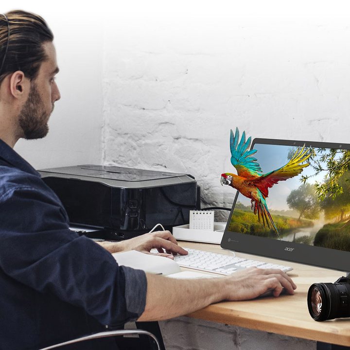 A man sits at his desk using a Acer SpatialLabs 3D monitor.