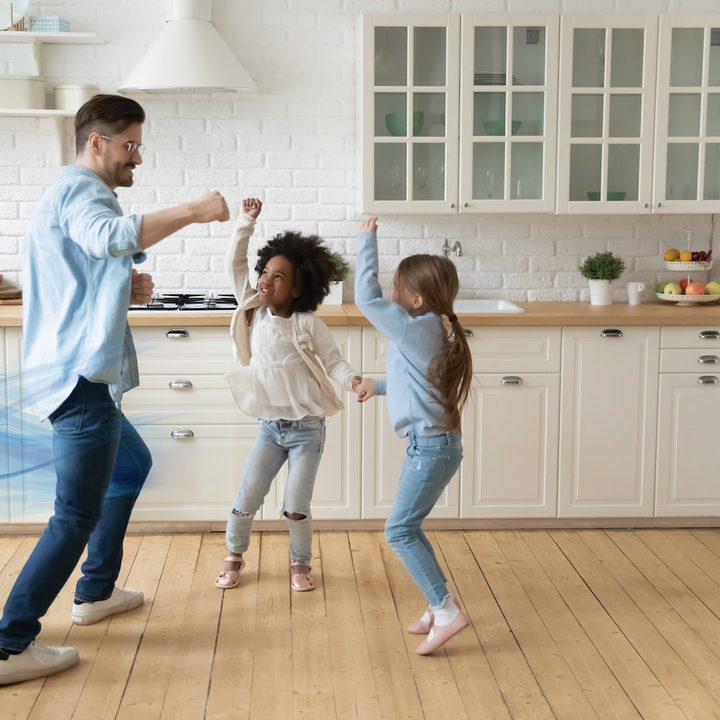 A man and two children dance in the kitchen beside the AeroTower.