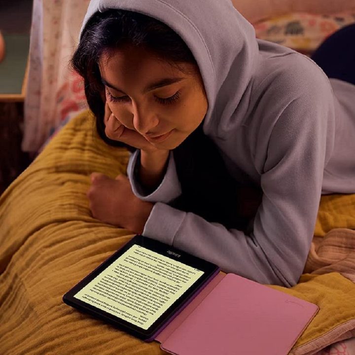 A girl reading an e-book on the Amazon Kindle Paperwhite Kids.