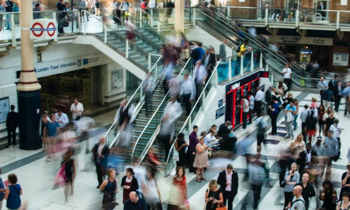 Time lapse of people walking and standing inside a busy shopping mall.