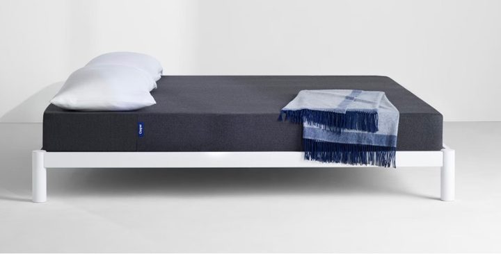 This is a Casper Snug mattress on a white bed frame with a white background.