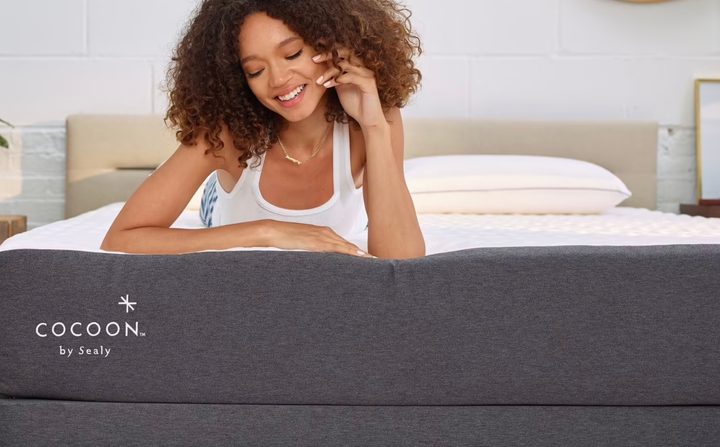 This image is a model on top of a Cocoon by Sealy memory foam mattress.