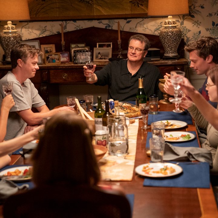 Colin Firth raises a glass at a family dinner in The Staircase.