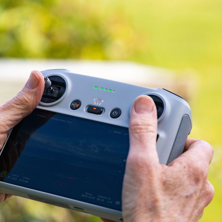 The DJI RC remote piloting the DJI Mini 3 Pro.