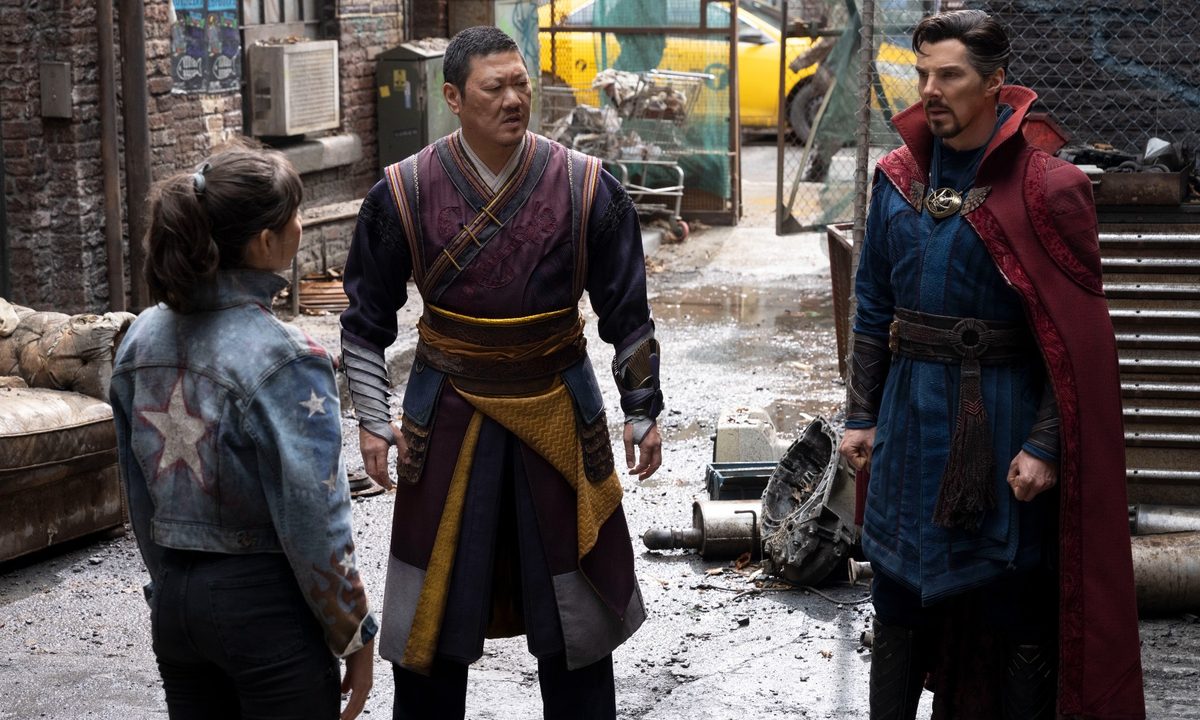 Xochitl Gomez, Benedict Wong, and Benedict Cumberbatch stand on a street in a scene from Doctor Strange in the Multiverse of Madness.