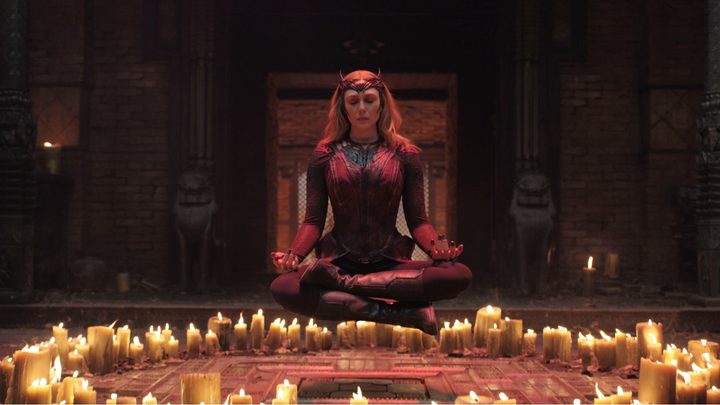 Scarlet Witch levitates in a circle of candles.