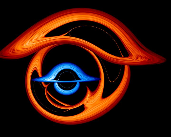This image shows the warped view of a larger supermassive black hole (red) when it passes almost directly behind a companion black hole (blue) with half its mass. The gravity of the foreground black hole transforms its partner into a surreal collection of arcs.