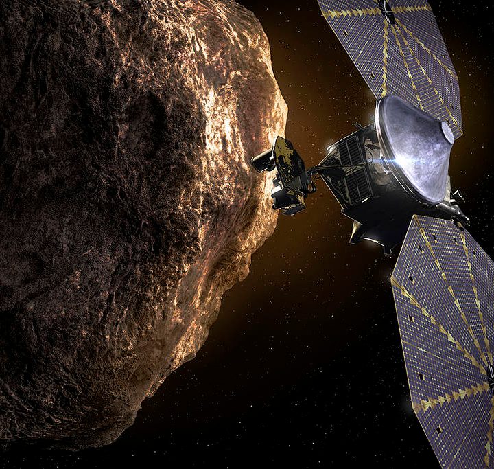This illustration shows the Lucy spacecraft passing one of the Trojan Asteroids near Jupiter.