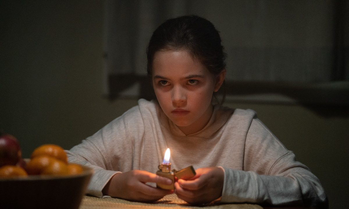 Ryan Kiera Armstrong lights a lighter in a scene from Firestarter.