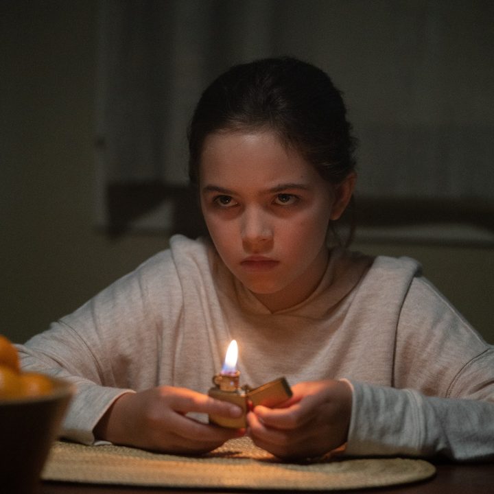 Ryan Kiera Armstrong lights a lighter in a scene from Firestarter.