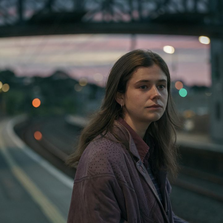 Frances stands by a set of train tracks in Conversations with Friends.