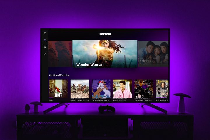 The HBO Max app on a TV screen while purple lights illuminate the wall behind.