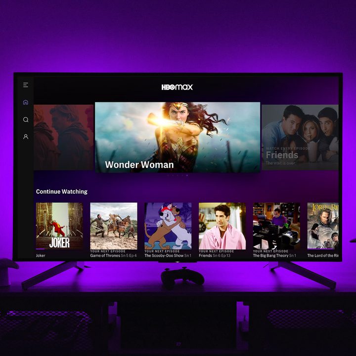 The HBO Max app on a TV screen while purple lights illuminate the wall behind.