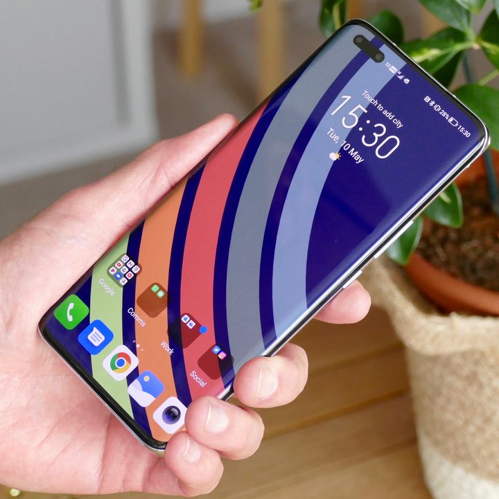 The Honor Magic4 Pro's screen showing wallpaper, held in a man's hand.