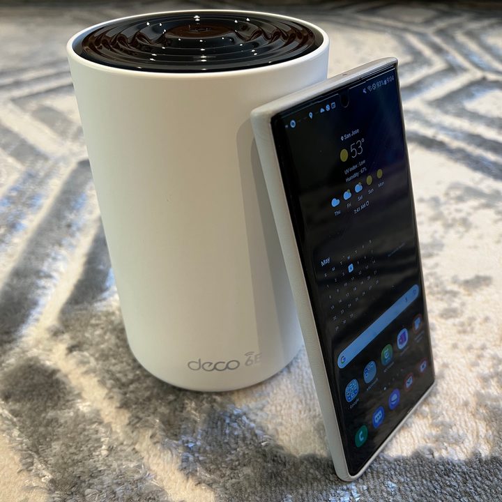 The TP-Link Deco XE75 next to the Galaxy S22 Ultra.