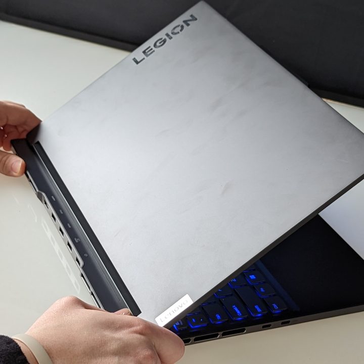 Hands grabbing the Lenovo Legion Slim 7i
