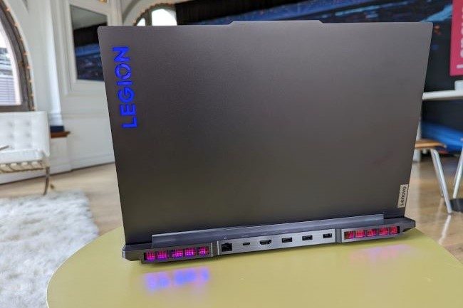 Lenovo Legion 7 laptop shot from the back with logo showing and RGB lighting showing on the table.