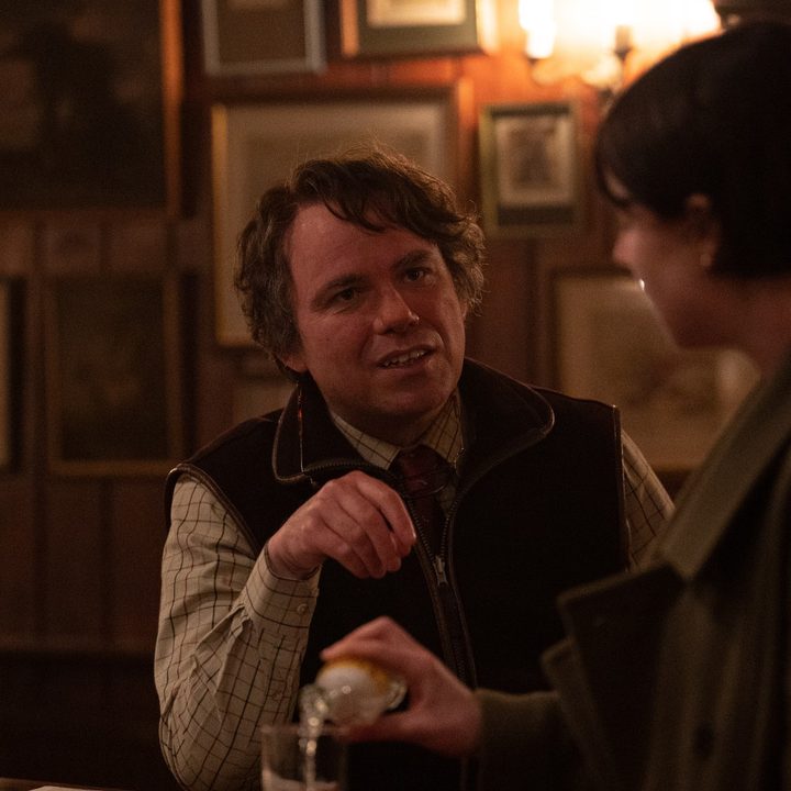 Rory Kinnear, as Geoffrey, speaks to Jessie Buckley's character in a pub in a scene from Men.