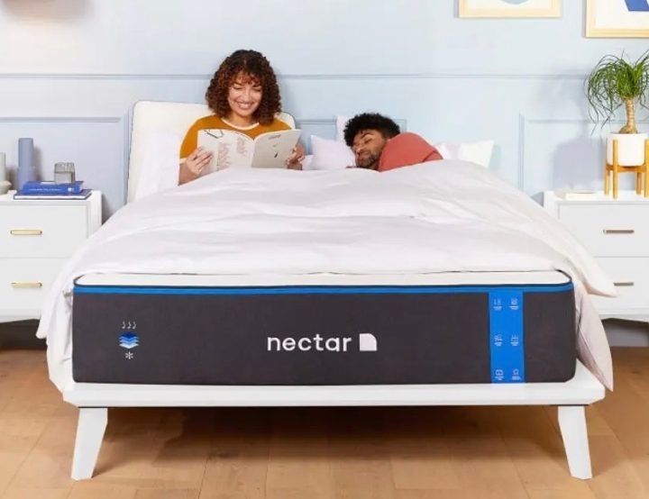 A couple rest on a Nectar Memory Foam Mattress in a bedroom.